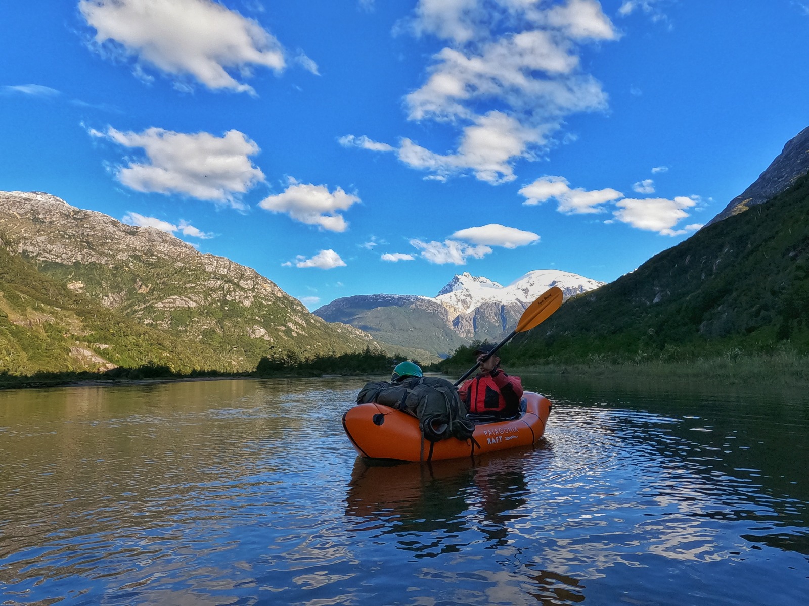 Remando en packraft por el río con cordillera al fondo